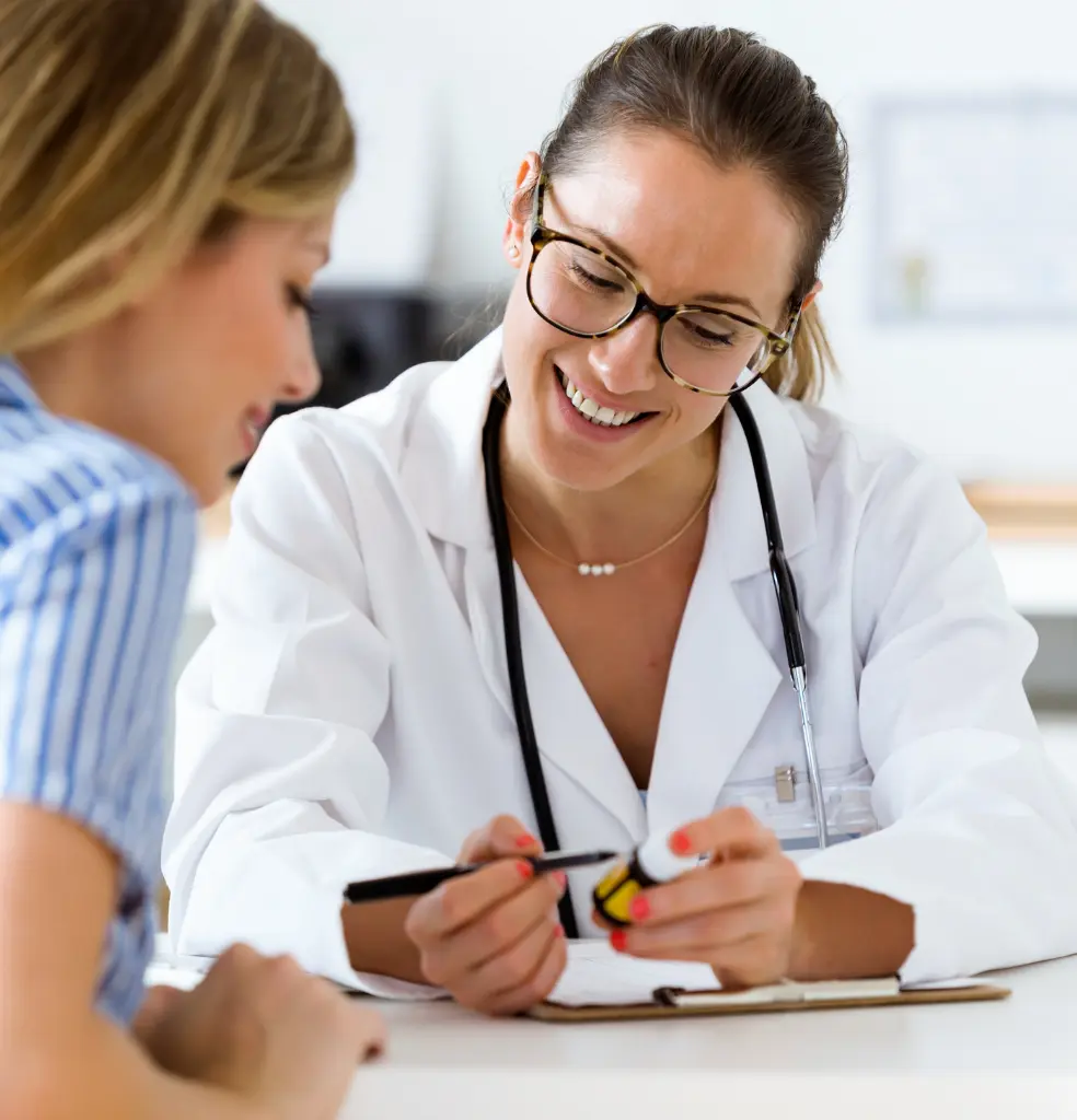 Smiling clinician reviewing paperwork with a patient at a practice